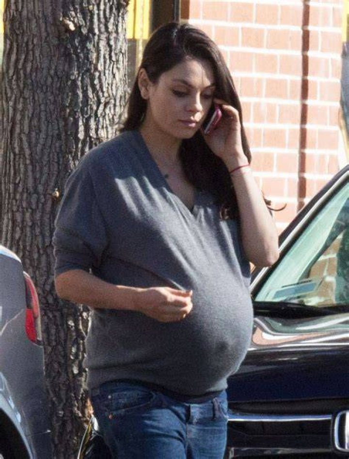 A pregnant Mila Kunis is pictured breaking the wall separating her family home's kitchen and living room | Source: