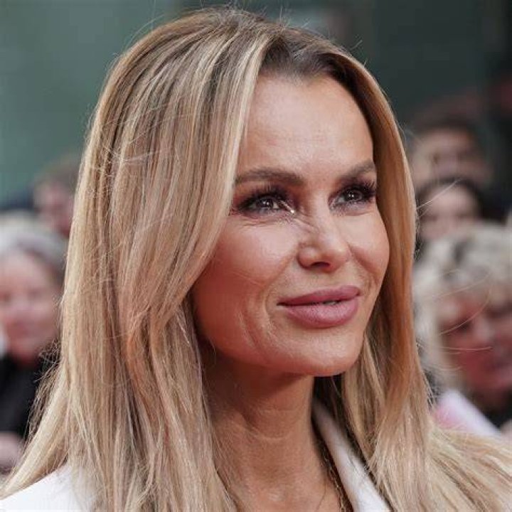 amanda holden posing on steps in white mini dress with matching heels and gloves