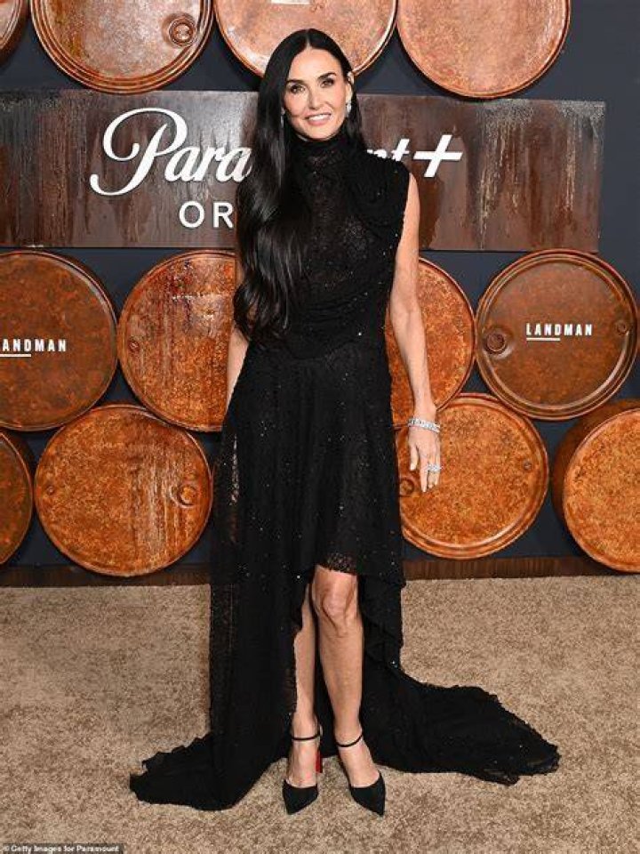 Demi Moore pictured wearing a black fringed, leather coat with a beige outfit in 1985. / Source: Getty Images