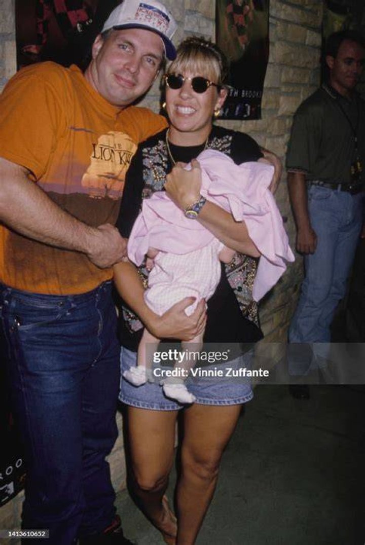 Garth Brook beside his wife Sandy Mahl holding their infant daughter in 1994