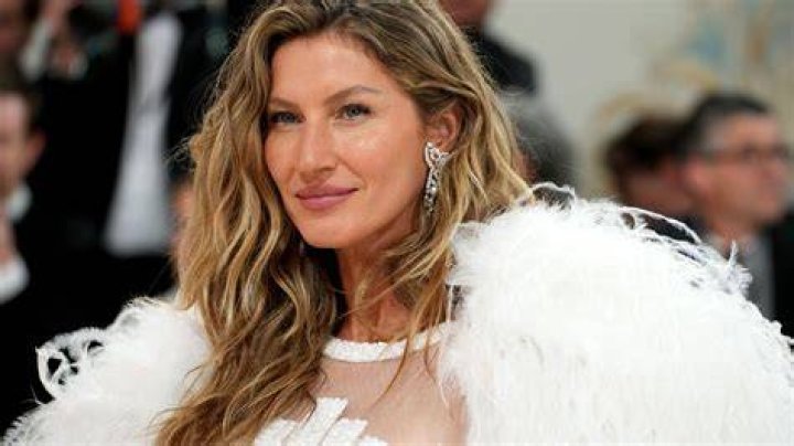 Gisele Bundchen waves in feathers