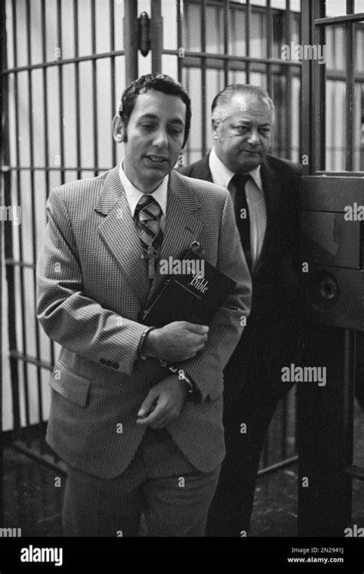 Joseph Kallinger, his wrists handcuffed, is framed between prison bars as he is led from Dauphin County Prison in Harrisburg for a lineup, on Jan. 27, 1975.
