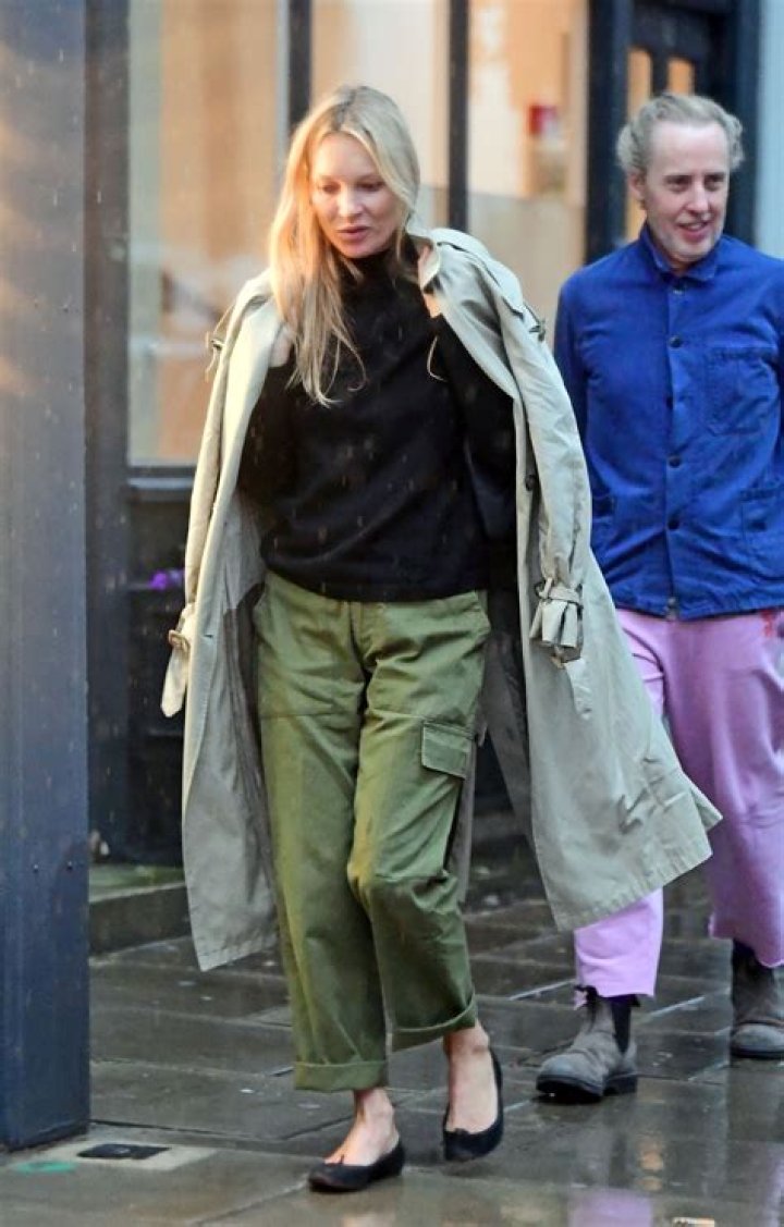 Kate Moss wearing a green shimmery slip with a feather in her hair 