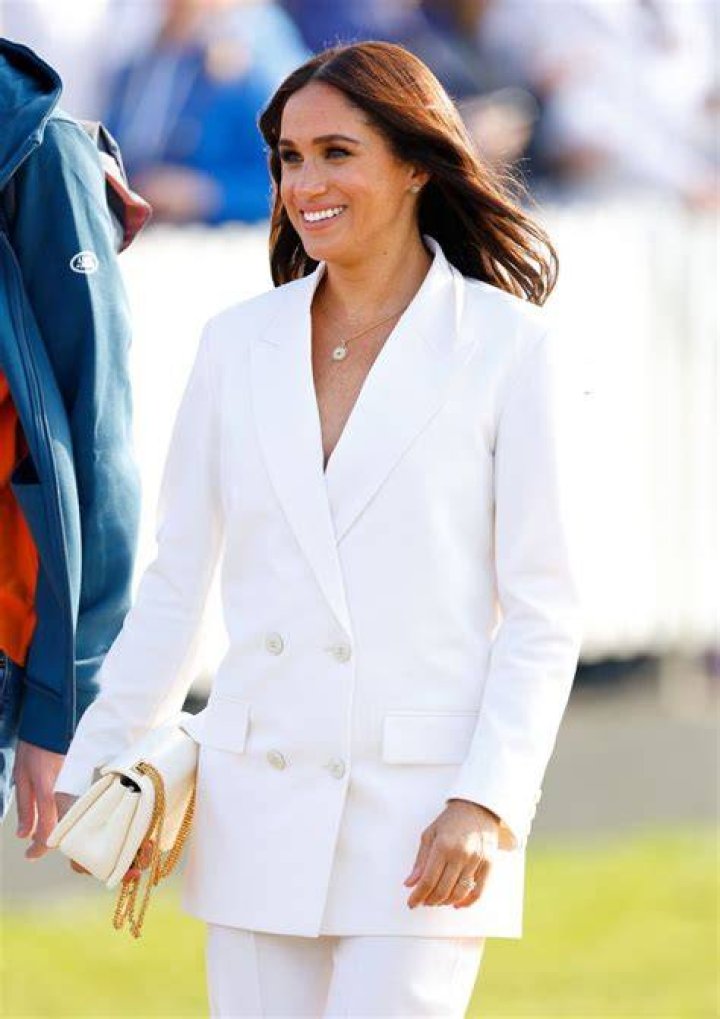 Meghan smiling in white blazer 