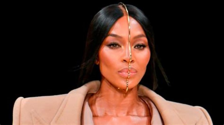 Naomi Campbell wearing a gold beaded micro top with layered necklaces 