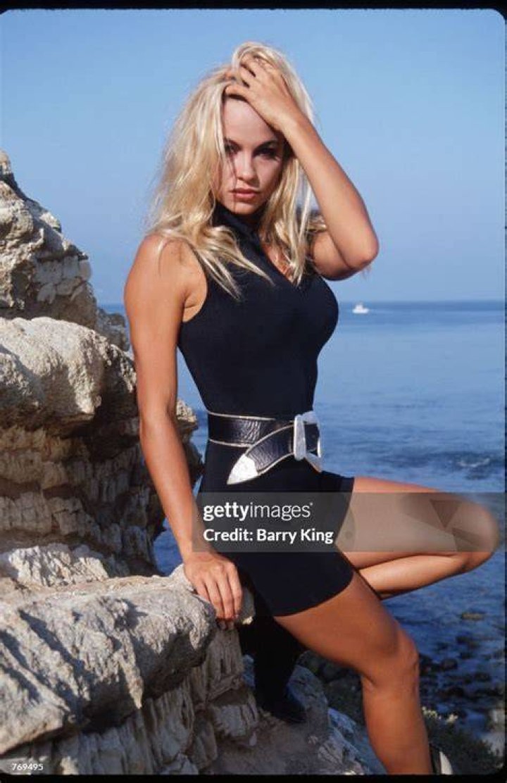 Pamela Anderson poses in a black bodysuit by the ocean. | Source: Getty Images