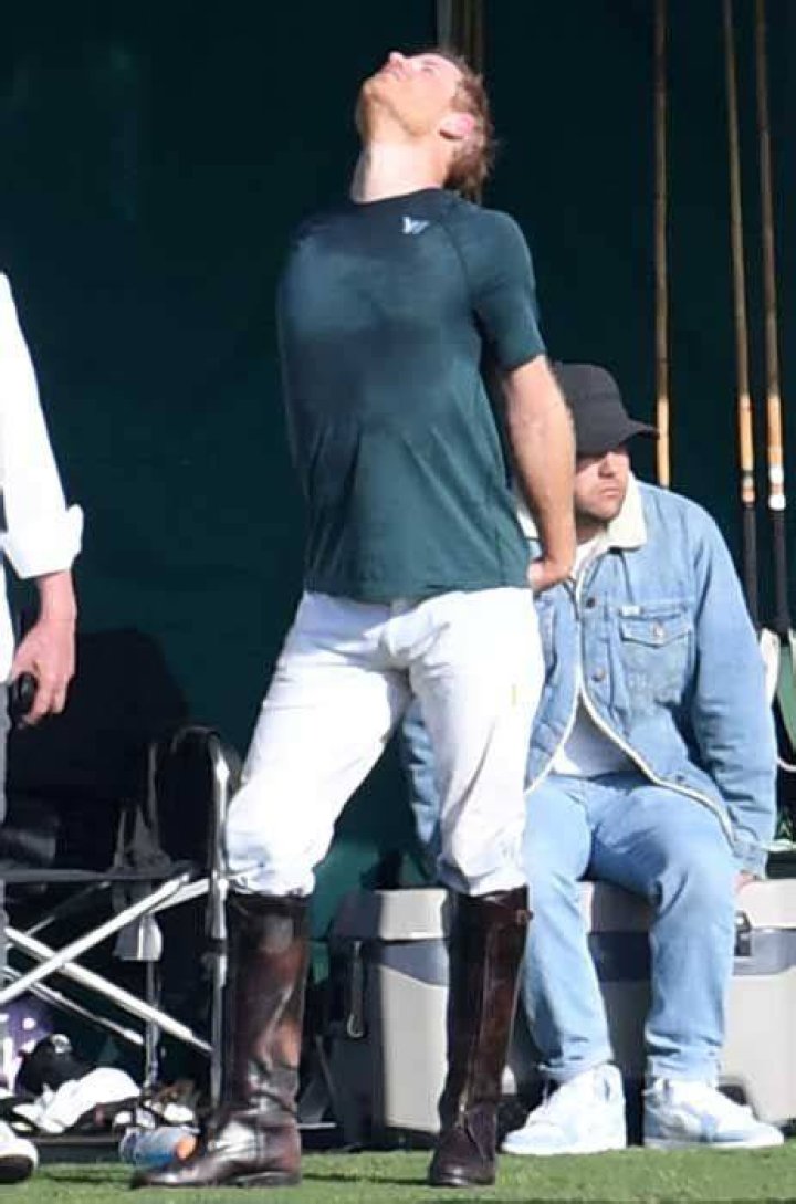 prince harry stretching after playing polo in a sweat soaked top