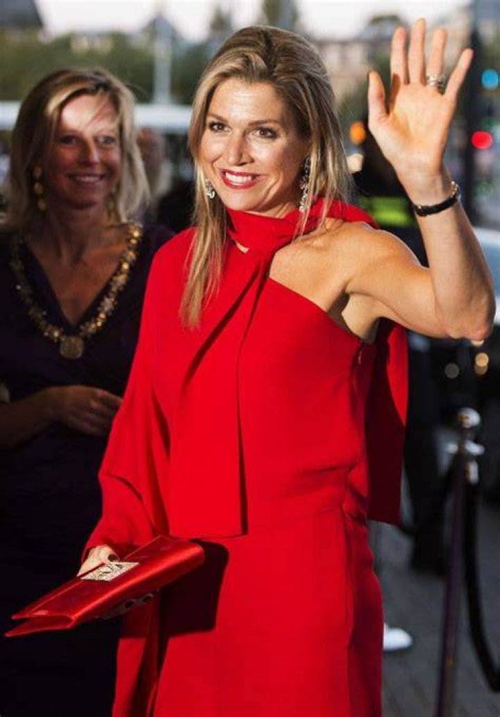 Queen Maxima waving in red dress and hat