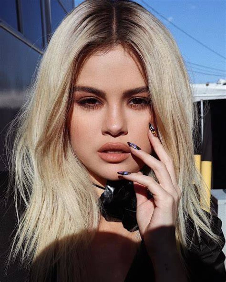 Selena Gomez with blonde hair posing for a photo