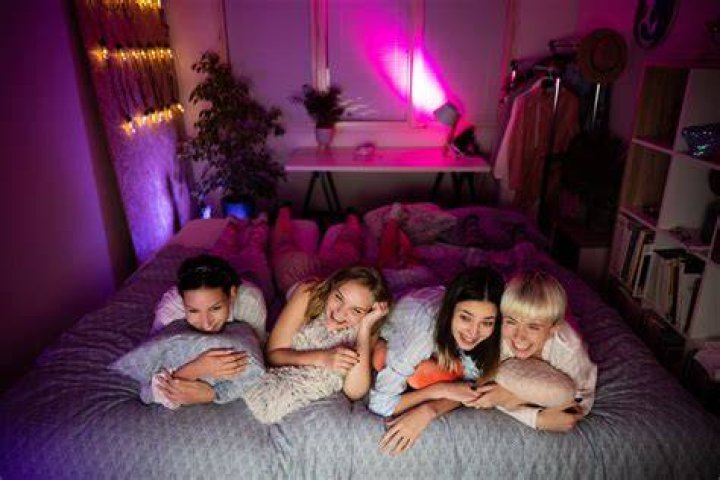 Sleepover: The girls shared prosecco on ice as they reclined in bed.
