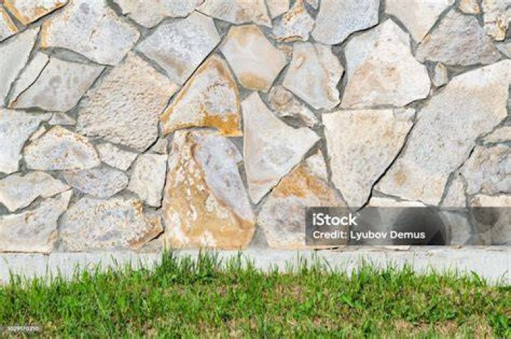 Stone building next to grass lawn and brook
