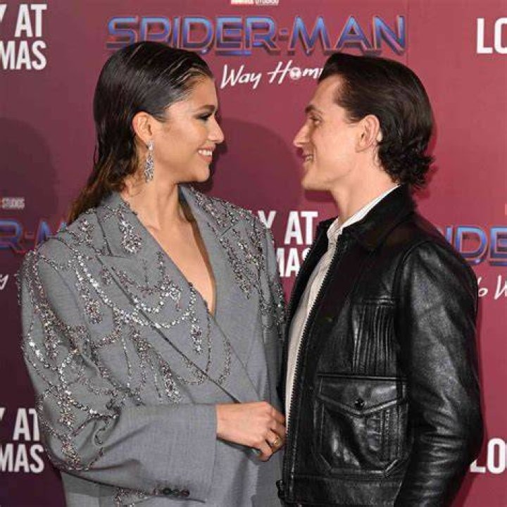 Tom Holland and Zendaya smiling on a red carpet