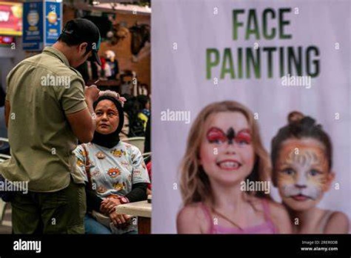Visitors with faces painted as catrinas pose for photos at Mexico City&acute;s main square the Zocalo, ahead of the Day of the Dead celebrations, Tuesday, Oct. 31, 2023. (AP Photo/Marco Ugarte)