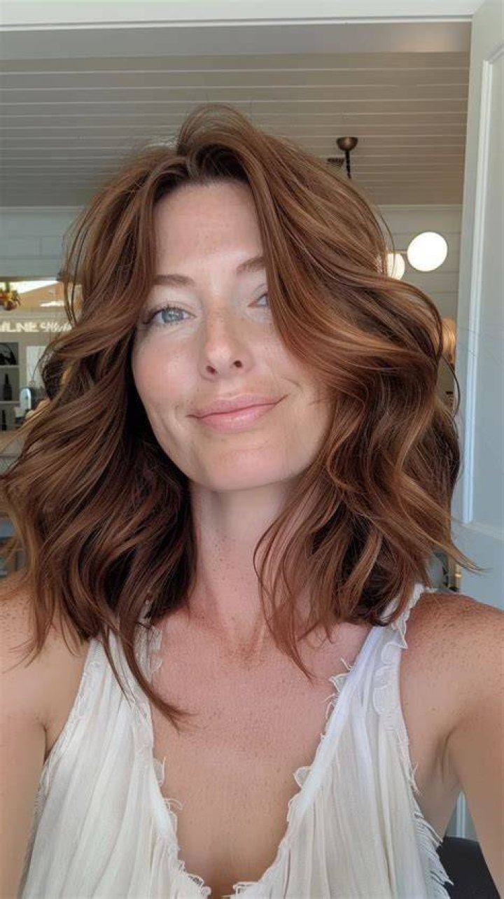 Windswept: She styled her chestnut locks in effortless waves and flicked them away from her glowing visage which was enhanced with a light palette of make-up